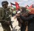 Israeli soldier gestures in front of Palestinian protesters during demonstration marking Land Day near Hebron