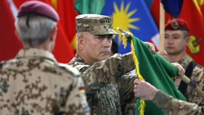 U.S. General John Campbell, commander of NATO-led International Security Assistance Force (ISAF), folds the flag of the ISAF during the change of mission ceremony in Kabul