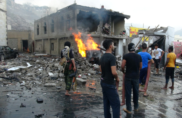 Bystanders look on at the carnage following a suicide car bombing in the Yemeni city of Aden (AFP)
