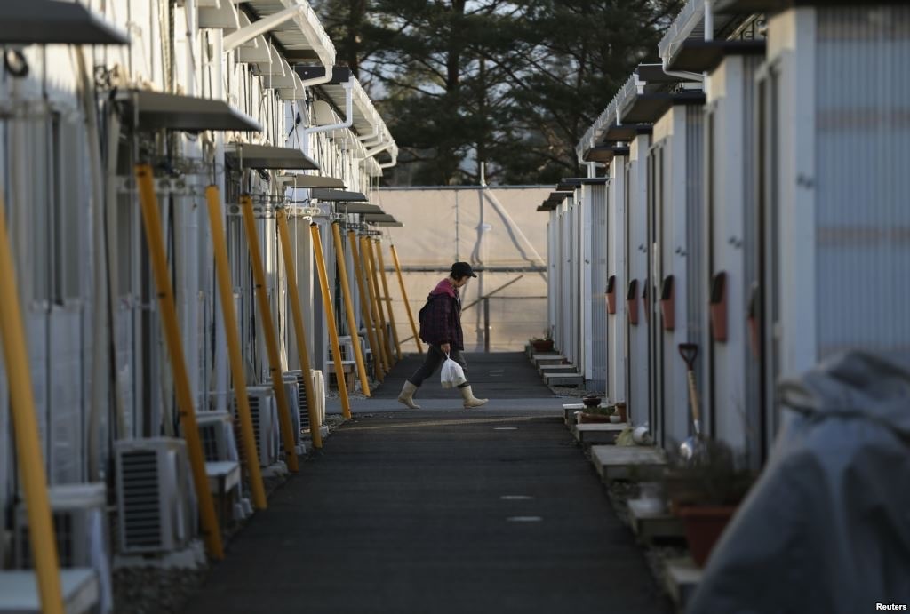 A woman walks in a temporary housing complex where evacuees from the Miyakoji area of Tamura are living, at Funahiki area in Tamura, Fukushima prefecture, April 1, 2014.(REUTERS/Issei Kato)