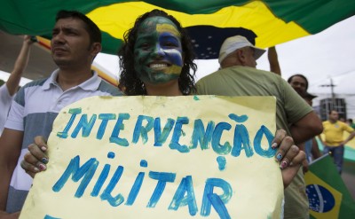 Woman shows a placard reading "Military intervention" during a protest against Brazil's President Dilma Rousseff in Manaus