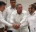 The landmark handshake between Juan Manuel Santos and Timoshenko, with two helping hands from Cuban President Raul Castro. (Justice for Colombia).